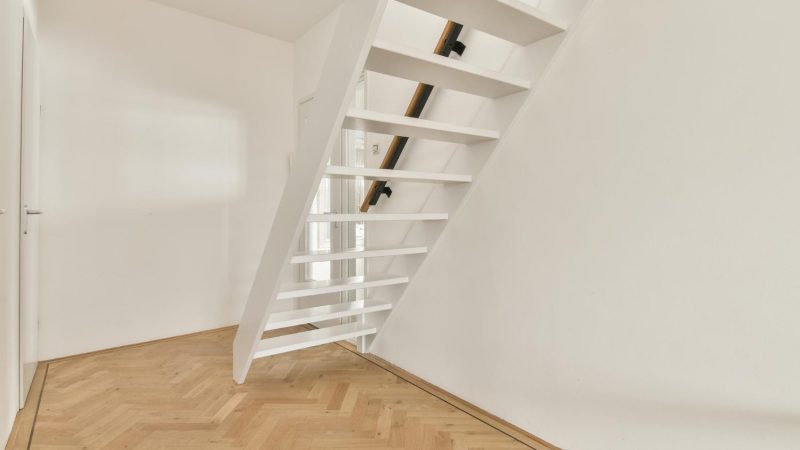 Newly installed loft staircase with wooden steps and white walls