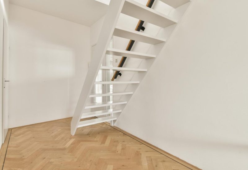 Newly installed loft staircase with wooden steps and white walls