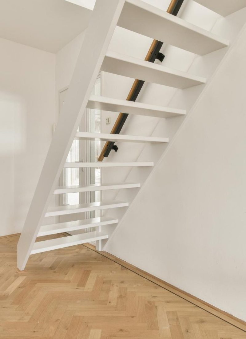 Newly installed loft staircase with wooden steps and white walls