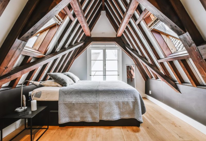 Bright loft bedroom conversion with Velux roof windows and wooden beams
