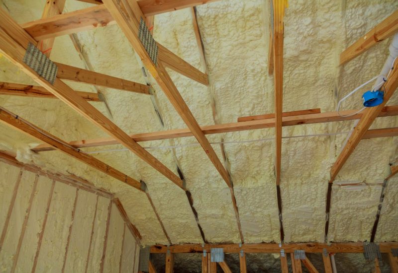 Mineral wool insulation being installed between loft roof rafters