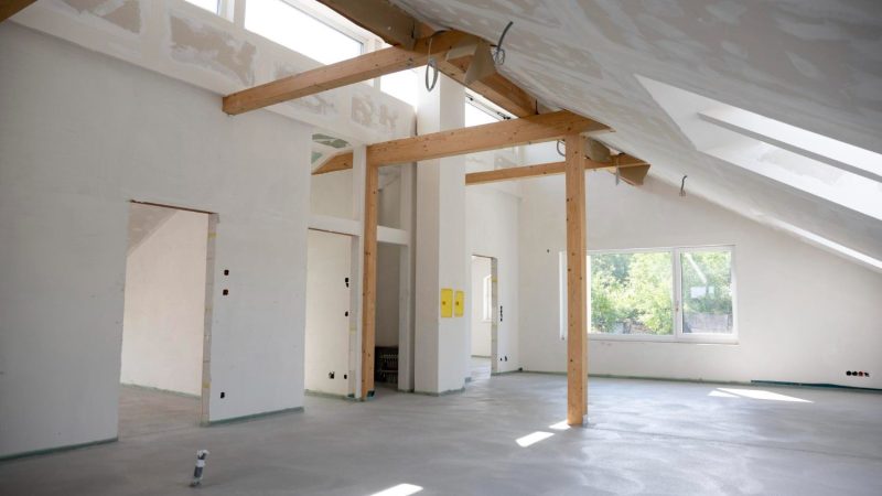 Converted loft room with exposed timber A-frame structure and Velux window