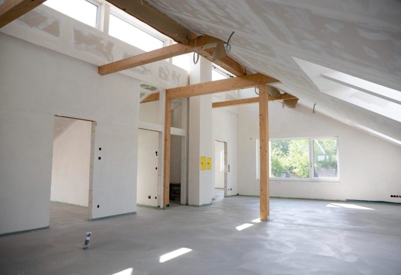 Converted loft room with exposed timber A-frame structure and Velux window