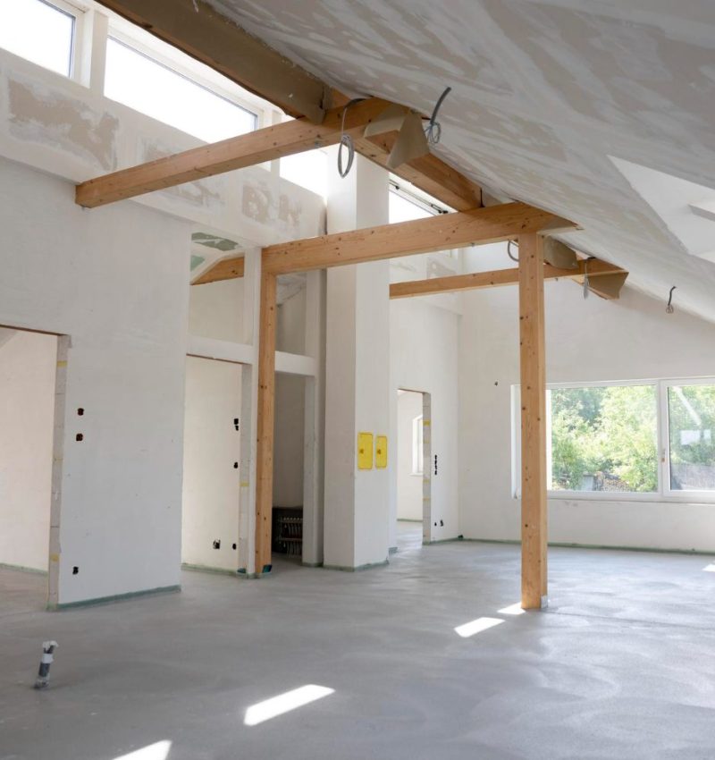 Converted loft room with exposed timber A-frame structure and Velux window
